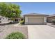 Charming single-story home features a neutral facade, tiled roof, 2-car garage, and mature landscaping at 15960 W Indigo Ln, Surprise, AZ 85374