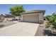 Single-story home boasts a neutral facade, tile roof, two-car garage, and low-maintenance landscaping at 15960 W Indigo Ln, Surprise, AZ 85374