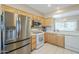 Well-equipped kitchen with stainless steel refrigerator and appliances, and light wood cabinets at 15960 W Indigo Ln, Surprise, AZ 85374