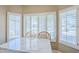 Kitchen island with marble countertop, wooden chairs, and white shutters for lots of natural light at 15960 W Indigo Ln, Surprise, AZ 85374