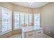 Kitchen island with a marble countertop, wooden chairs, and large shuttered windows at 15960 W Indigo Ln, Surprise, AZ 85374