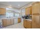 Open kitchen layout with light wood cabinets, white countertops, and views into other rooms at 15960 W Indigo Ln, Surprise, AZ 85374