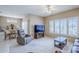 Bright living room with a ceiling fan, large windows, and an open layout to the dining area at 15960 W Indigo Ln, Surprise, AZ 85374