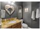 Stylish powder room features a granite countertop, a decorative mirror, and elegant fixtures at 16645 W Papago St, Goodyear, AZ 85338