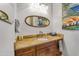 This well-lit bathroom showcases a granite counter, vanity, and framed mirror above the sink at 16645 W Papago St, Goodyear, AZ 85338