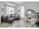 Cozy sitting area with gray sofa and ottoman; the space features light walls and neutral decor at 16645 W Papago St, Goodyear, AZ 85338