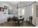 Bright dining room featuring a dark wood table, lovely artwork, and natural light from multiple windows at 16645 W Papago St, Goodyear, AZ 85338