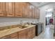 Well-equipped laundry room with wood cabinets, granite countertops, modern washer, and dryer at 16645 W Papago St, Goodyear, AZ 85338
