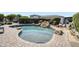 Backyard pool with rock waterfall, landscaped edges, and a surrounding paver deck at 16645 W Papago St, Goodyear, AZ 85338