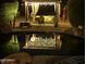 Night view of a backyard pool reflecting a softly lit cabana, creating a serene and inviting atmosphere at 16645 W Papago St, Goodyear, AZ 85338