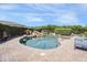 Stunning backyard pool with a rock waterfall feature, surrounded by lush landscaping and lounge chairs at 16645 W Papago St, Goodyear, AZ 85338