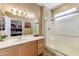 Well-maintained bathroom with a large mirror, a walk-in shower, and a single sink vanity at 16857 W Villagio Dr, Surprise, AZ 85387