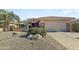 Attractive home featuring desert landscaping, a two-car garage, and a private courtyard with a serene patio at 16857 W Villagio Dr, Surprise, AZ 85387