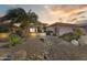 Inviting desert-landscaped front yard with a stately palm tree and a charming rock-lined dry creek bed at 16857 W Villagio Dr, Surprise, AZ 85387