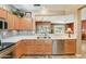 Open concept kitchen featuring stainless appliances, light cabinets, and a view into the living and dining area at 16857 W Villagio Dr, Surprise, AZ 85387