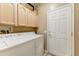 Bright laundry room featuring a white washer and dryer, cabinets and a door at 16857 W Villagio Dr, Surprise, AZ 85387