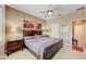 Serene bedroom with a ceiling fan and two nightstands with lamps, providing a cozy and inviting atmosphere at 16857 W Villagio Dr, Surprise, AZ 85387