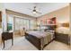 Comfortable main bedroom with neutral tones, a large window, ceiling fan, and ample space for furniture at 16857 W Villagio Dr, Surprise, AZ 85387
