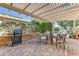 Outdoor patio seating and BBQ under a trellis at 16857 W Villagio Dr, Surprise, AZ 85387