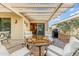 Inviting covered patio area with a glass table, comfortable seating, and a built-in barbeque at 16857 W Villagio Dr, Surprise, AZ 85387