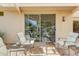 Cozy outdoor seating area with a covered patio and a view of the garden through sliding glass doors at 16857 W Villagio Dr, Surprise, AZ 85387