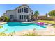 This backyard boasts a sparkling pool, lush landscaping, covered patio, and a spacious grassy area at 1694 E Campbell Ave, Gilbert, AZ 85234