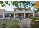 Expansive backyard featuring a covered patio, outdoor fireplace, lush landscaping, and secure pool fencing at 1707 E Carob Dr, Chandler, AZ 85286