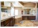 Bathroom with tile flooring, granite countertops, dark wood cabinetry, a tub and shower, and large mirrors at 1707 E Carob Dr, Chandler, AZ 85286