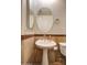 Well lit bathroom featuring a white pedestal sink and an oval mirror, accented with brown patterned tiling at 1707 E Carob Dr, Chandler, AZ 85286
