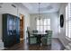 Bright dining room featuring wood floors, tray ceiling, and black display cabinet at 1707 E Carob Dr, Chandler, AZ 85286