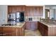 Gourmet kitchen boasts stainless appliances, rich wood cabinets, and granite countertops at 1707 E Carob Dr, Chandler, AZ 85286