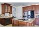 Spacious kitchen features stainless appliances, wood cabinets, granite counters, and an island cooktop at 1707 E Carob Dr, Chandler, AZ 85286