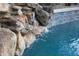 Pool water feature with stacked rocks, waterfall, and tiled backdrop create a relaxing and luxurious backyard oasis at 1707 E Carob Dr, Chandler, AZ 85286