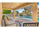 Covered patio featuring cozy seating, overlooking the pool and landscaped backyard at 18518 E Ashridge Dr, Queen Creek, AZ 85142