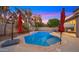 Inviting backyard pool with umbrellas, patio seating, and lush landscaping at 18518 E Ashridge Dr, Queen Creek, AZ 85142