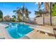 Backyard oasis featuring a sparkling pool, diving board, and lush landscaping at 18518 E Ashridge Dr, Queen Creek, AZ 85142