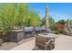 View of outdoor kitchen with built-in grill, table and chairs, and patio umbrella at 20121 N 76Th St # 2058, Scottsdale, AZ 85255
