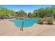 Resort-style community pool surrounded by mature trees, rock features, and comfortable lounge seating at 20121 N 76Th St # 2058, Scottsdale, AZ 85255