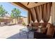 Inviting covered patio with comfortable seating, privacy curtains, and view of backyard at 20603 W Alsap Rd, Buckeye, AZ 85396