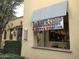 Exterior view of a barbershop with traditional signage and a classic barber pole at 20603 W Alsap Rd, Buckeye, AZ 85396