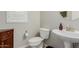 Well-lit half bath with a pedestal sink, white toilet, and wood-look floor at 20603 W Alsap Rd, Buckeye, AZ 85396