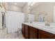 Well-lit bathroom with double sink vanity, white shower curtain, and decorative art at 20603 W Alsap Rd, Buckeye, AZ 85396
