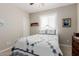 Cozy bedroom features a metal bed frame, quilt bedding, and natural light from window at 20603 W Alsap Rd, Buckeye, AZ 85396