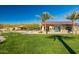 Beautiful clubhouse with lush green lawn, palm trees and resort-style outdoor seating and mountain views in the background at 20603 W Alsap Rd, Buckeye, AZ 85396
