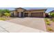 Expansive driveway leading to a two-car garage, complemented by beautiful stone and desert landscaping at 20603 W Alsap Rd, Buckeye, AZ 85396