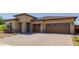 Inviting exterior showcasing a well-manicured front yard, stone accents, and a two-car garage at 20603 W Alsap Rd, Buckeye, AZ 85396