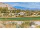 Picturesque golf course with green grass and desert landscaping featuring mountain views at 20603 W Alsap Rd, Buckeye, AZ 85396