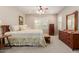 Spacious main bedroom featuring wooden furniture, ceiling fan, and shuttered windows at 20603 W Alsap Rd, Buckeye, AZ 85396