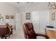 Office space featuring wood desk, rolling leather chair and lots of wall art at 20603 W Alsap Rd, Buckeye, AZ 85396
