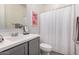 Contemporary bathroom featuring gray vanity, white sink, and shower with curtain at 21824 S 226Th Pl, Queen Creek, AZ 85142